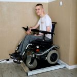 Mężczyzna na wózku inwalidzkim korzystający ze specjalnej wagi dostosowanej dla osób z niepełnosprawnością