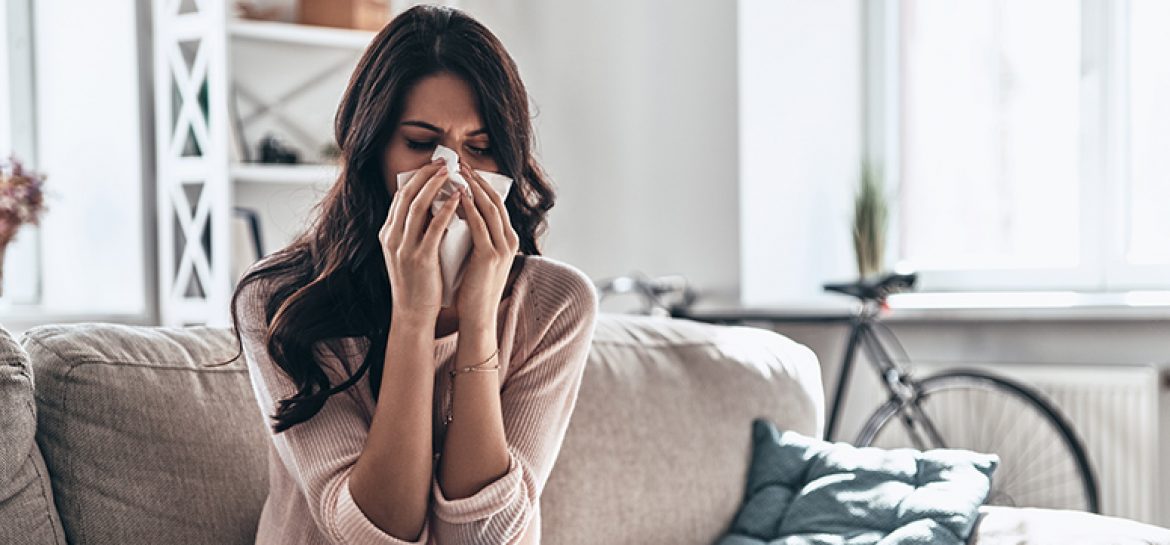 Na zdjęciu przedstawiona jest kobieta z alergią, w danym momencie kicha