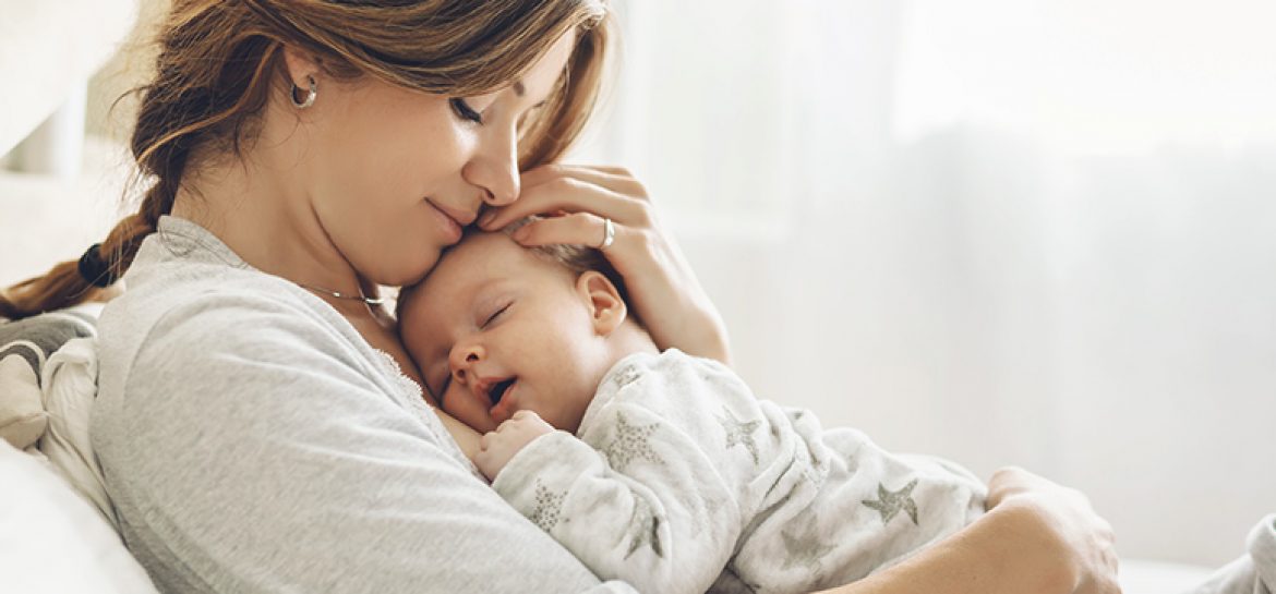 Na zdjęciu przedstawiono kobietę, która przytula niemowlę
