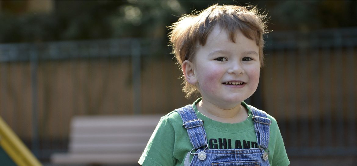 Zdjęcie przedstawia uśmiechnięte dziecko